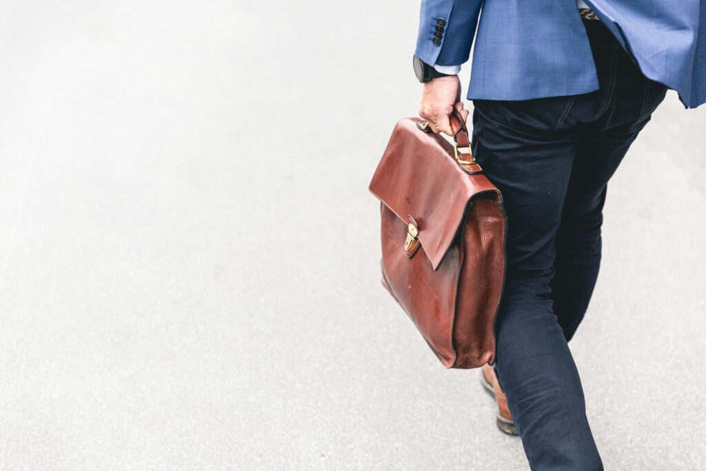 An image showing a person carrying a briefcase on their way to an airport transfer