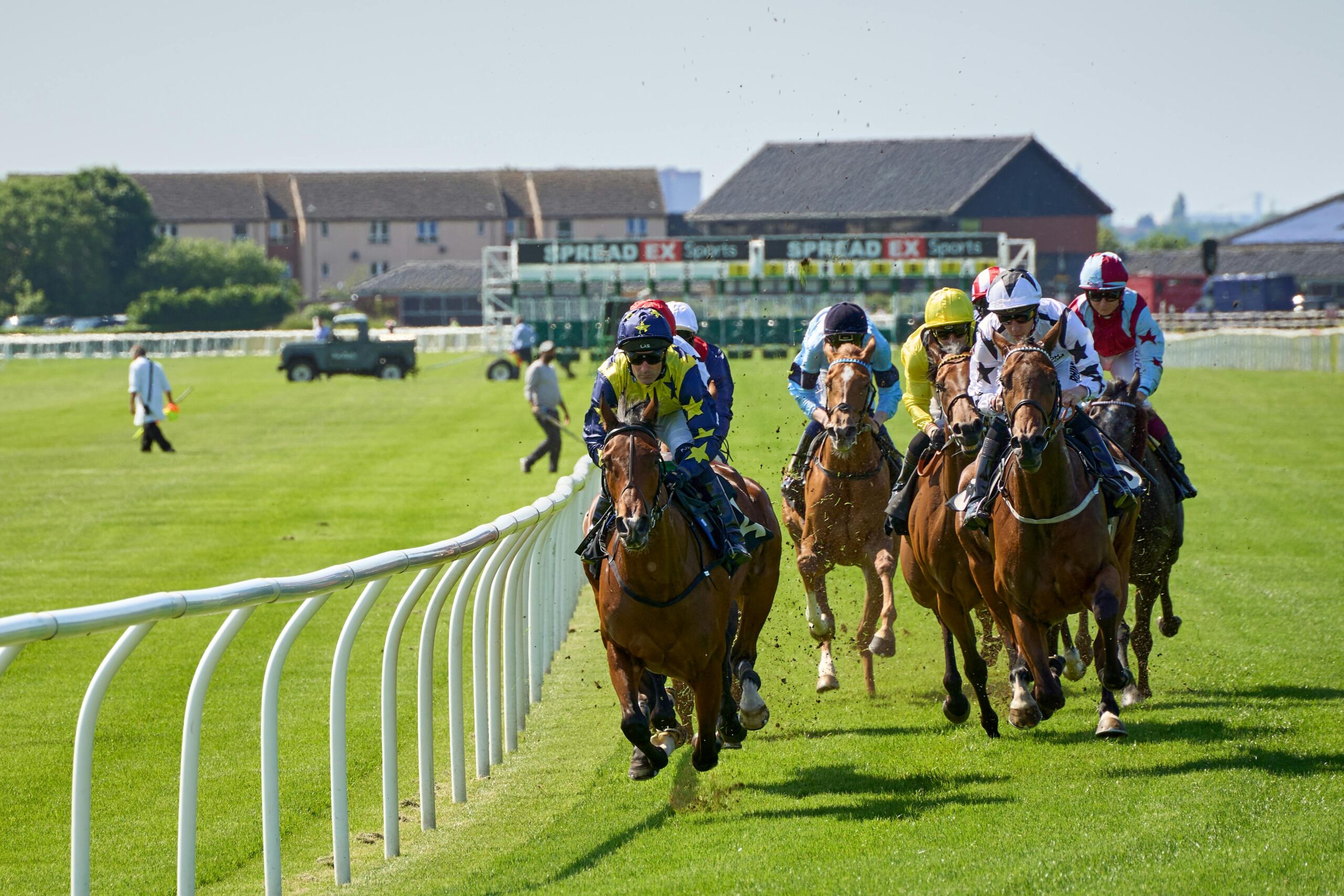 An image showing jockeys racing at a prestigious race course in the UK