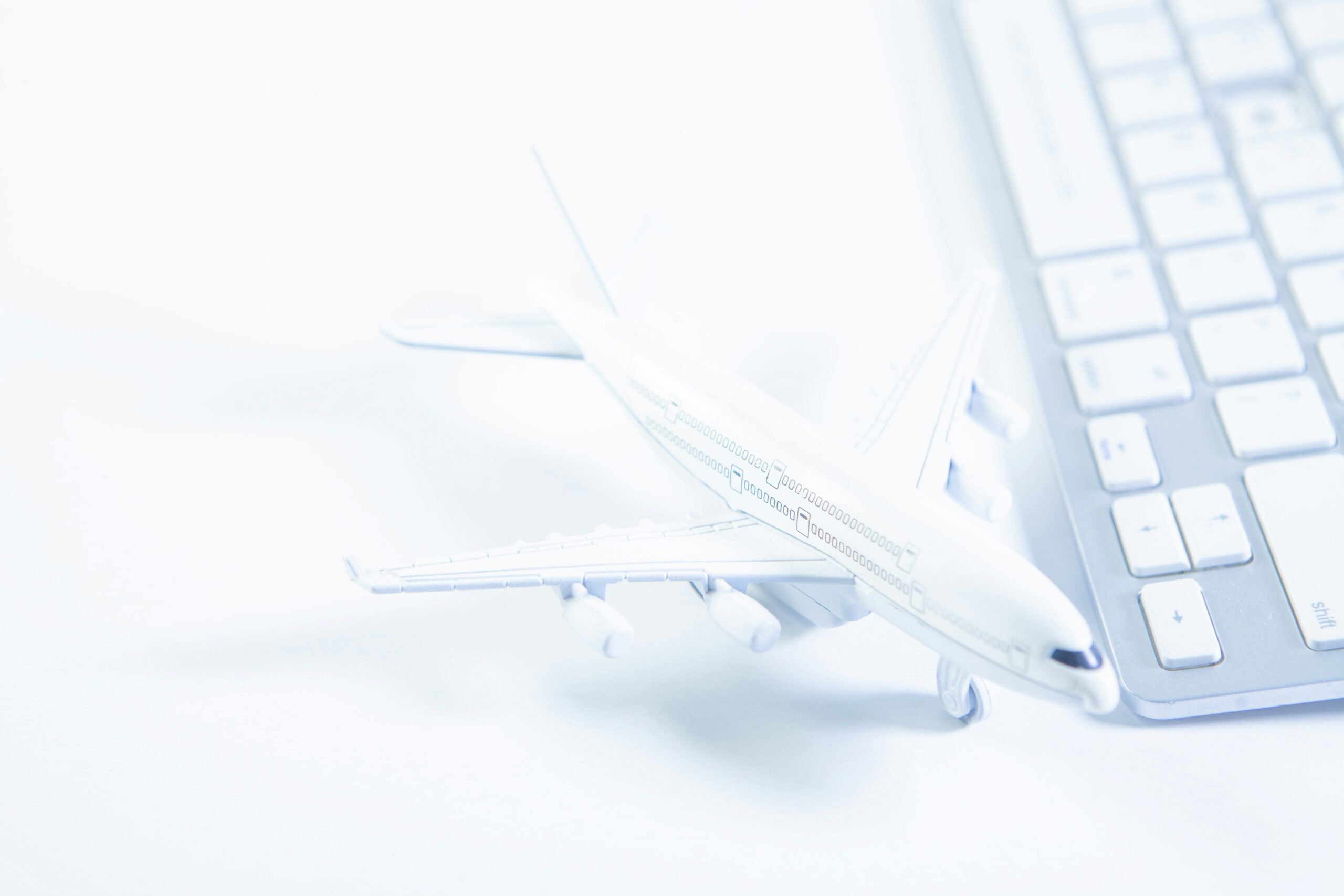 An image showing a toy plane next to the keyboard of a laptop